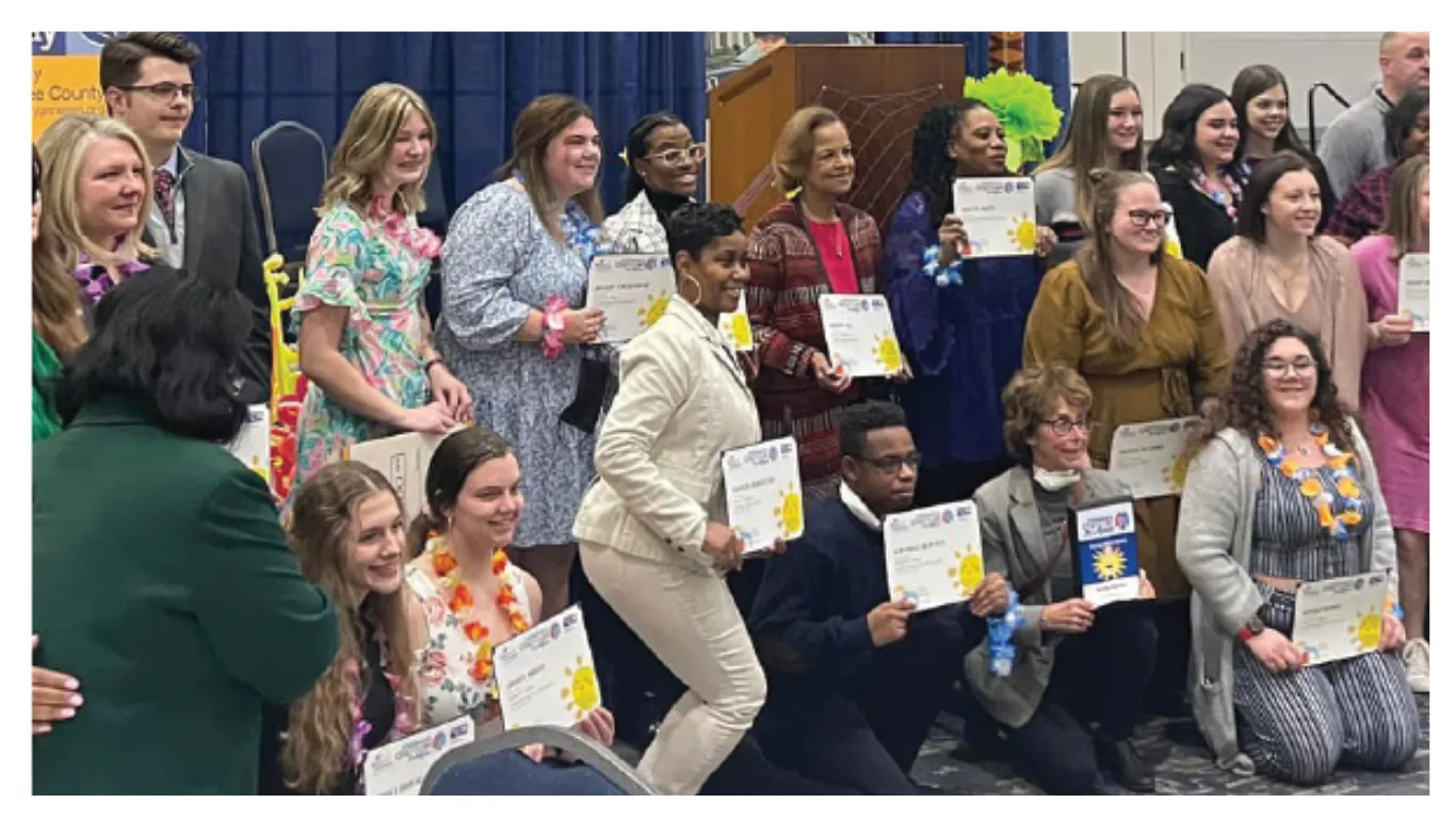 Group holding certificates at an awards event
