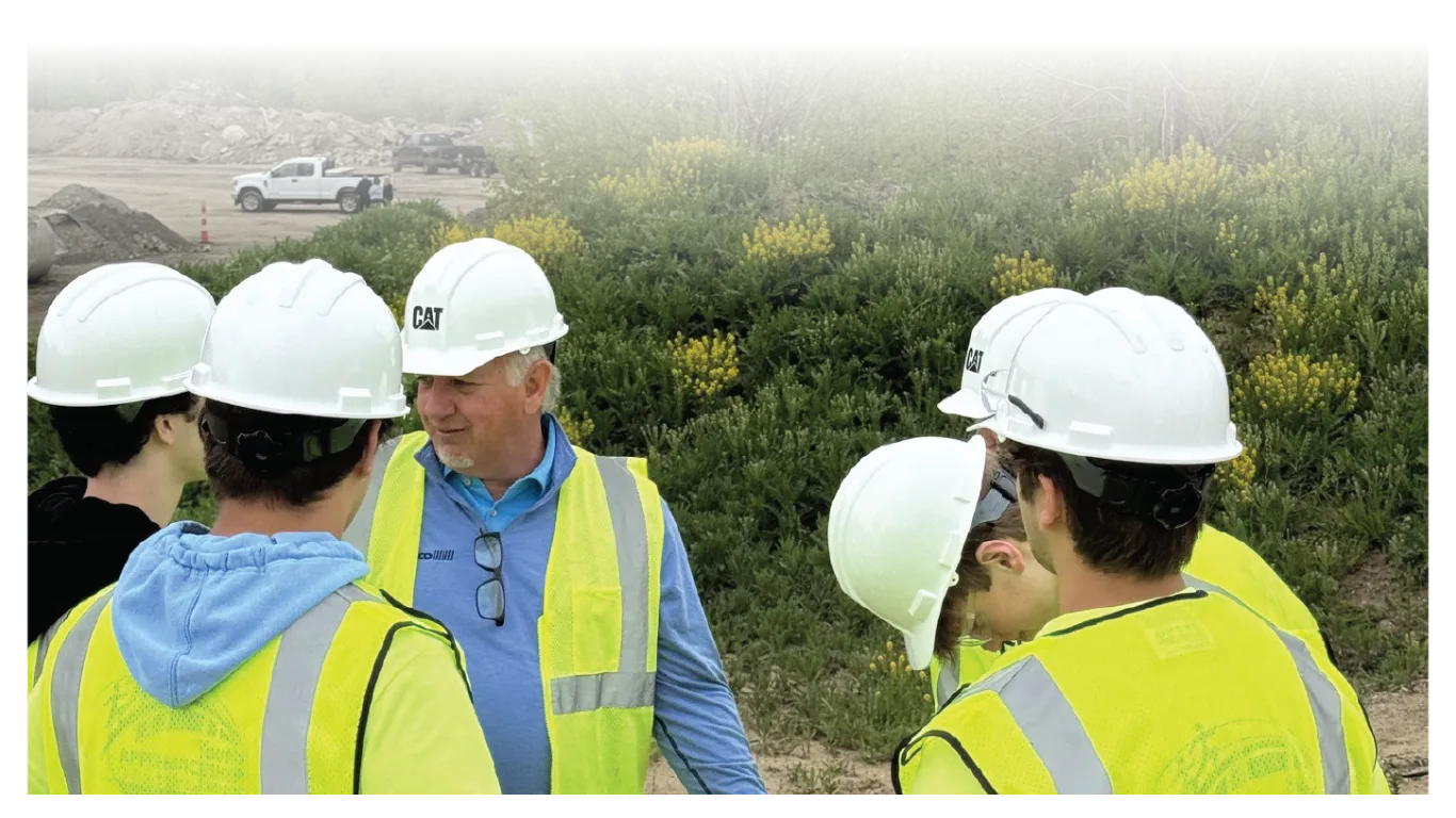 CurbCo team member talking with a group in hard hats on a job site