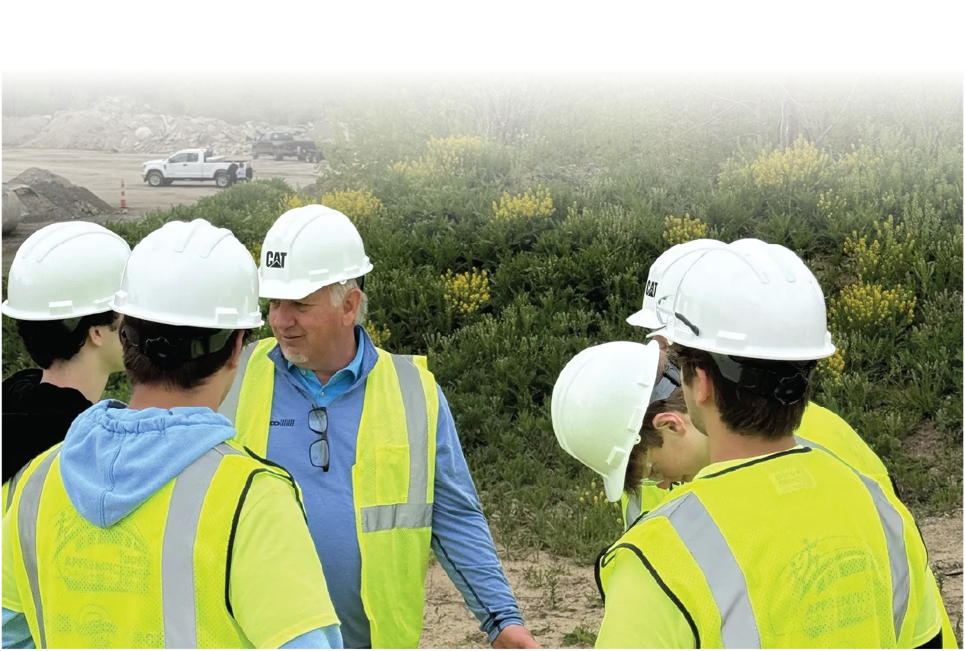 Job site conversation with a group in hard hats and safety vests